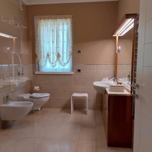 a bathroom with two sinks and a toilet and a window at CasaRò in Albano SantʼAlessandro +28 photos