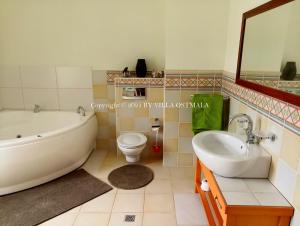 a bathroom with a tub and a toilet and a sink at Villa Ostmala in Ventspils +82 photos