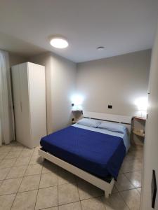 um quarto com uma cama azul num quarto em Valle dell'Eden em Grottammare