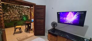 a living room with a flat screen tv on a wall at Casa na serra a 10 min de Guaramiranga! Ótima para descanso com conforto e para turismo! in Pacoti