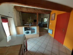- une cuisine avec une porte rouge et un comptoir dans l'établissement Gite de Pascal et Virginie, à Ponet-et-Saint-Auban