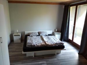 1 dormitorio con 1 cama en una habitación con ventana en Valéria Vendégház, en Balatonföldvár