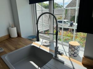 a kitchen sink in front of a kitchen window at The Haven at Halsons in Bridport