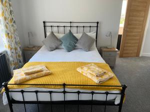 a bedroom with a bed with two towels on it at The Haven at Halsons in Bridport