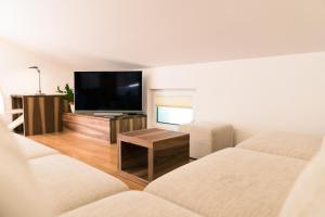 a living room with two couches and a flat screen tv at Apartma Tale in Kobarid