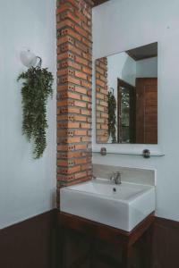 a bathroom with a white sink and a mirror at Villa Mungkala - Colonial Villa in Chiang Rai