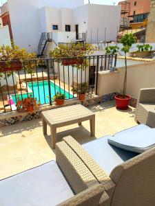 un patio con mesa, sillas y piscina en Morfeo Charming Rooms & Relax, en Avola