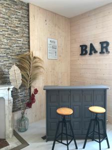 um bar com dois bancos em frente a uma parede em L'Oréline au cœur de la région des Lacs du Jura em Pont-de-Poitte