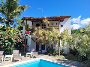 a villa with a swimming pool in front of a house at REFUGiO MINEIRO HOTEL BOUTIQUE in Mamoan