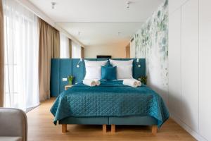 a bedroom with a blue bed with white pillows at InPoint Apartments G15 near Old Town & Kazimierz District & Optional Paid Parking in Krakow