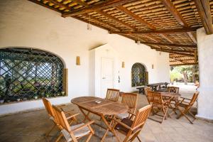 een patio met houten tafels en stoelen bij Kite Hostel Stagnone in Marsala