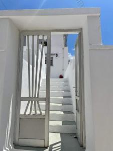 a door to a white building with stairs at Traditional SeamansHouse Kochilos in Rogón