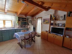a kitchen with a table with chairs and a television at La Calletta in Rovinj