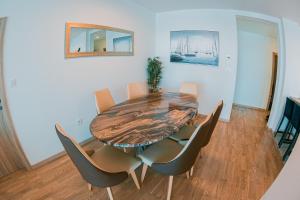 a dining room with a wooden table and chairs at Kaneo beach hotel Novalja in Novalja