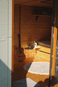 um quarto com uma guitarra, uma mesa e uma cama em V dedine a predsa mimo nej v maringotke na samote em Dechtice