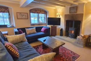 uma sala de estar com um sofá azul e uma mesa em Candle House, Winster, in the Peak District em Winster