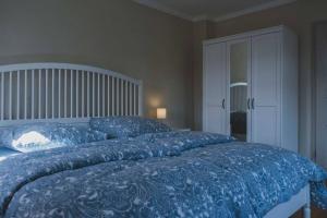 a bedroom with a bed with a blue comforter at Moderne Wohnung im Herzen der Natur - Ingo's Dream in Bäbelin