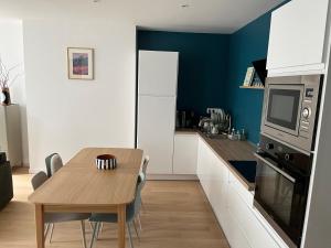 une cuisine avec une table en bois et une salle à manger dans l'établissement Le coquillage magique, à Granville