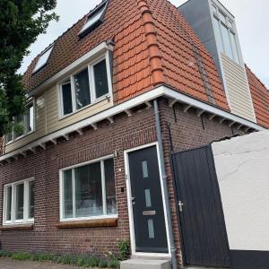 a red brick house with a black door at B&B Vintage Room in Vught