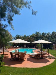 維耶斯泰的住宿－Villa Vittoria，一个带桌椅和遮阳伞的游泳池