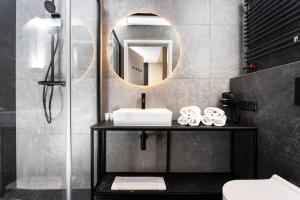 a bathroom with a sink and a mirror at InPoint Apartments G15 near Old Town & Kazimierz in Kraków