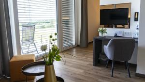 a hotel room with a desk and a large window at Hotel Kapelle in Radolfzell am Bodensee