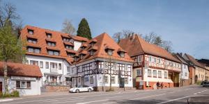 une voiture blanche garée devant les bâtiments dans une rue dans l'établissement Hotel Bär, à Sinsheim