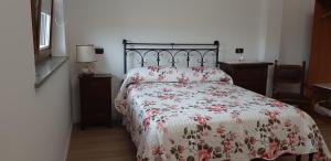 um quarto com uma cama com colcha floral em CASCINA LAI - Oasi Naturalistica - Camere private em Santena