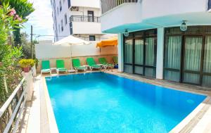 a swimming pool with chairs and a building at Kartel Hotel in Didim