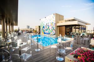 a restaurant with tables and chairs and a mural at Centro Mada Amman by Rotana in Amman