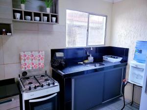 una pequeña cocina con fogones y fregadero en Casa Campina Grande-PB Internet 500MB, Netflix, Ar en Campina Grande