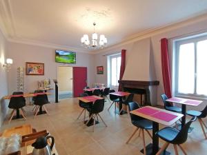 a classroom with tables and chairs and a piano at Hôtel Le Dormeux in Mehun-sur-Yèvre