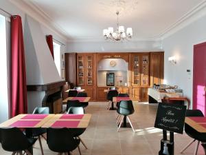 um restaurante com mesas e cadeiras num quarto em Hôtel Le Dormeux em Mehun-sur-Yèvre