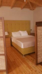 1 dormitorio con 1 cama y suelo de madera en Vila Thailanda in Katakolo en Pýrgos