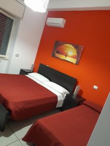 a hotel room with two beds and orange walls at Pompei Ruins in Pompei