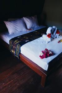 a bed with some flowers on top of it at Gili Mesari Cottages & Homestay in Gili Trawangan