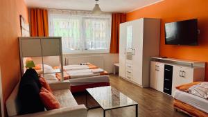 um quarto com duas camas e um sofá e uma televisão em Ubytování Lednice em Lednice