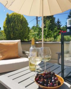 uma taça de uvas e uma garrafa de vinho numa mesa em Grand Terrace Apartment with AC & heating em Budapeste