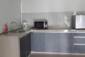Una encimera de cocina con un microondas y un fregadero. en Equine Park, Seri Kembangan, en Seri Kembangan 5 fotos más