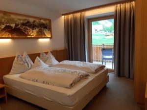 um quarto de hotel com uma cama e uma grande janela em Residence Haus Peder em Solda