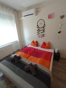 Turmalin Apartman في تشوباك: غرفة نوم مع سرير وبطانية ملونة