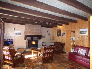 a living room with a couch and a fireplace at Domaine de Pratulo in Cléden-Poher