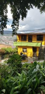 a yellow building with a table and chairs in front of it at Wonderful house with views in Medellin-fiber optics in Medellín