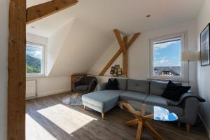 a living room with a blue couch and two chairs at Ferienwohnung am Steinbach 2 in Thale