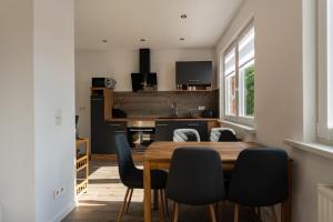 een keuken en eetkamer met een houten tafel en stoelen bij Ferienwohnung am Steinbach 2 in Thale