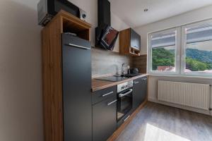 eine Küche mit einem schwarzen Kühlschrank und einem Fenster in der Unterkunft Ferienwohnung am Steinbach 2 in Thale