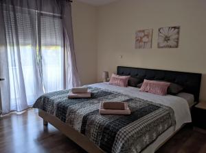 a bedroom with a large bed with pink pillows on it at Villa Longina in Ljubuški