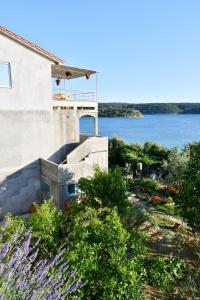 a building with a view of a body of water at Apartman Krstaš- Gonar in Supetarska Draga