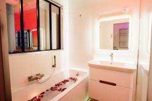 a bathroom with a sink and a bath tub with hearts on the floor at room five - parking, balnéothérapie, place nationale, un havre de paix in Montauban