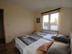 a bedroom with two beds and a window at Villa Longina in Ljubuški